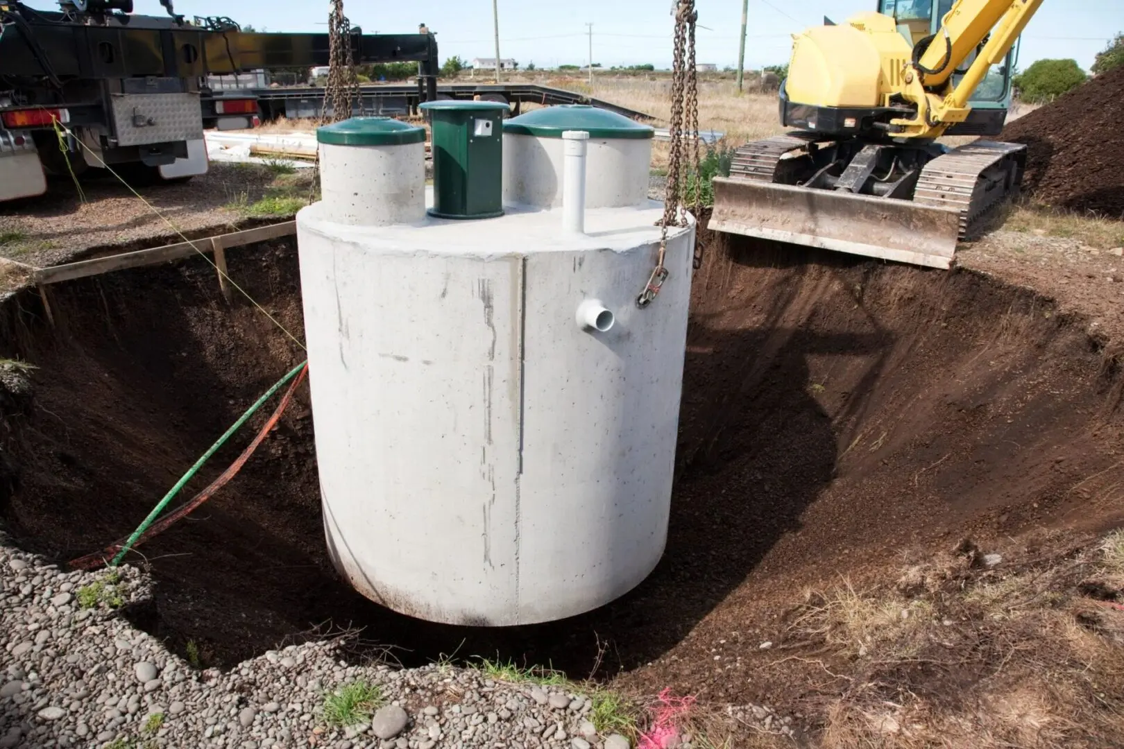 A white tank sitting in the middle of a dirt field.